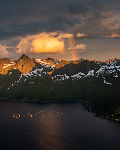 Montagne Couverte De Neige Près Du Lac Sous Ciel Nuageux