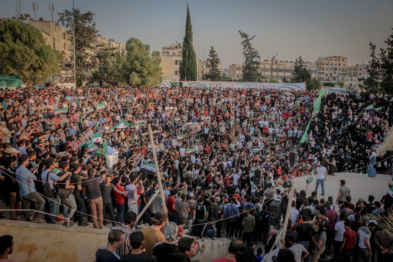 A large crowd watching an outdoor performance in a city square