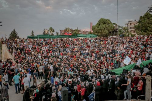 Free From above of overcast sky covered with clouds over trees in park next to crowd of demonstrators in daytime Stock Photo