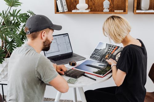 Free Two architecture colleagues collaborate over project designs in a modern office setting. Stock Photo