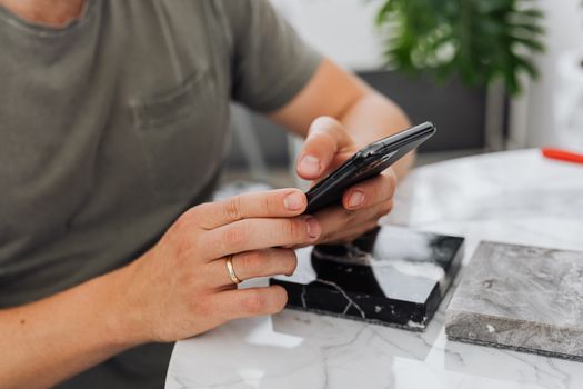Hands holding a smartphone with a blurred background in an indoor setting.