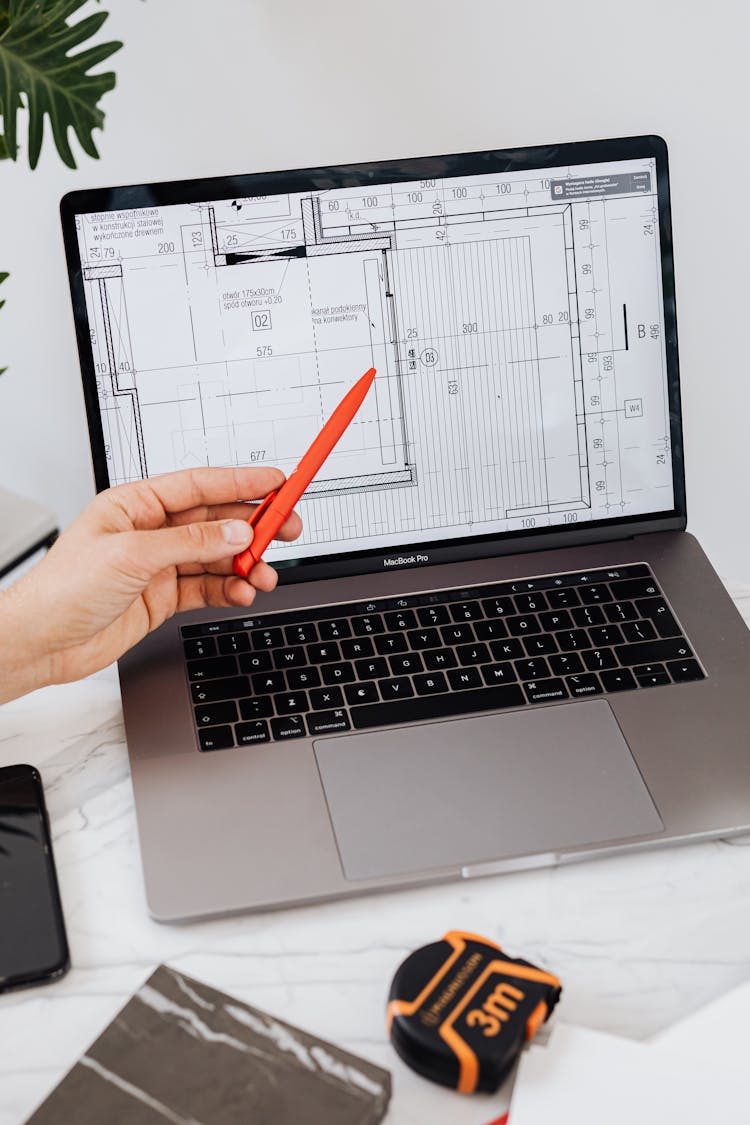 Person Holding A Pen And Pointing At A Screen