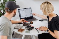 两名设计师在办公室用笔记本电脑和样本讨论建筑计划