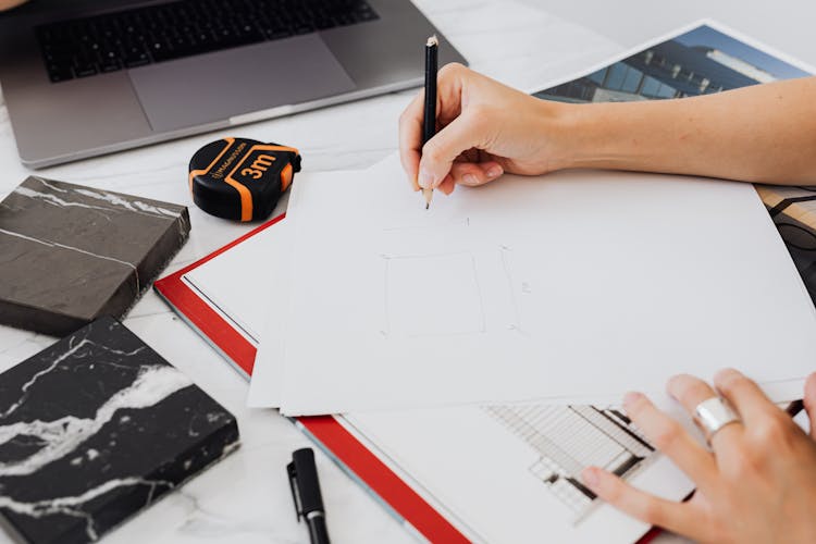 Close-up Of Person Making Blueprint On Paper