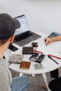 Man Wearing a Cap and Tile Samples on a Round Table