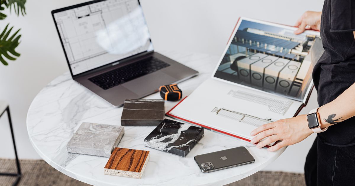 An organised workspace with both creative projects and business planning tools, representing balance in freelance work.