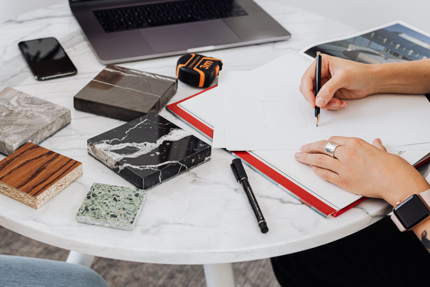 Interior design concept development with sketches and material samples on marble table