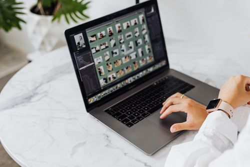 Free Close-up of hands using a laptop with a smartwatch on a marble table. Stock Photo