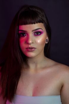 Elegant portrait of a woman with bold pink makeup and long hair.