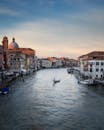 日落时分，威尼斯大运河的美丽景色与贡多拉和历史建筑交相辉映