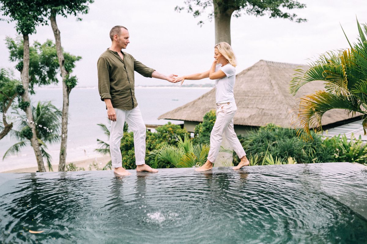 Couple holding hands near a pool
