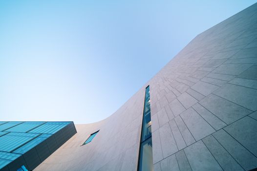 From below of contemporary multistory house facade with ornamental walls under sky in town