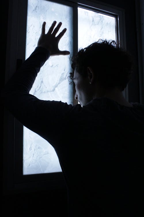 Free A Person Leaning on a Glass Window Stock Photo