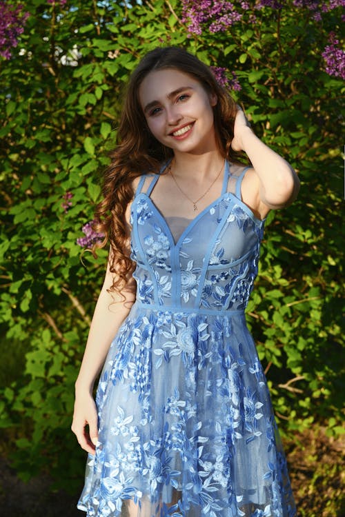 A Woman in Blue Floral Dress Standing in the Garden