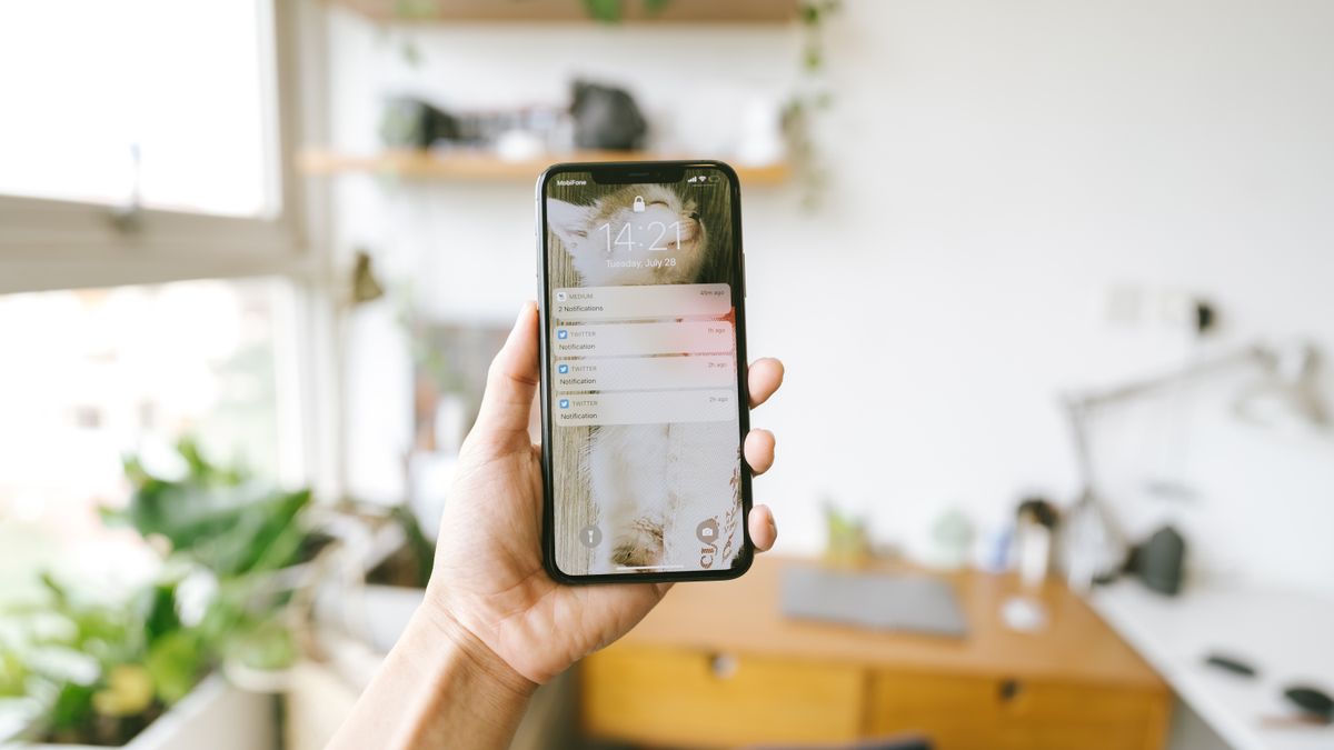 通知が並んだスマートフォン画面を持つ手元のイメージ
