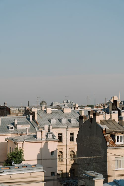 Free Charming cityscape with historic rooftops under a clear blue sky, capturing an urban summer atmosphere. Stock Photo