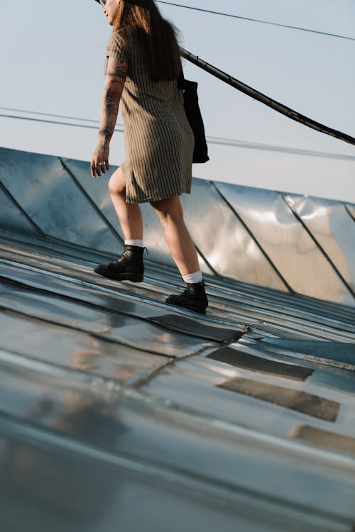 Woman in Black and White Striped Dress Standing on Black and White Bridge