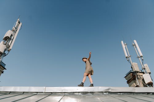 Mann In Den Braunen Kurzen Hosen, Die Auf Weißem Betongebäude Springen