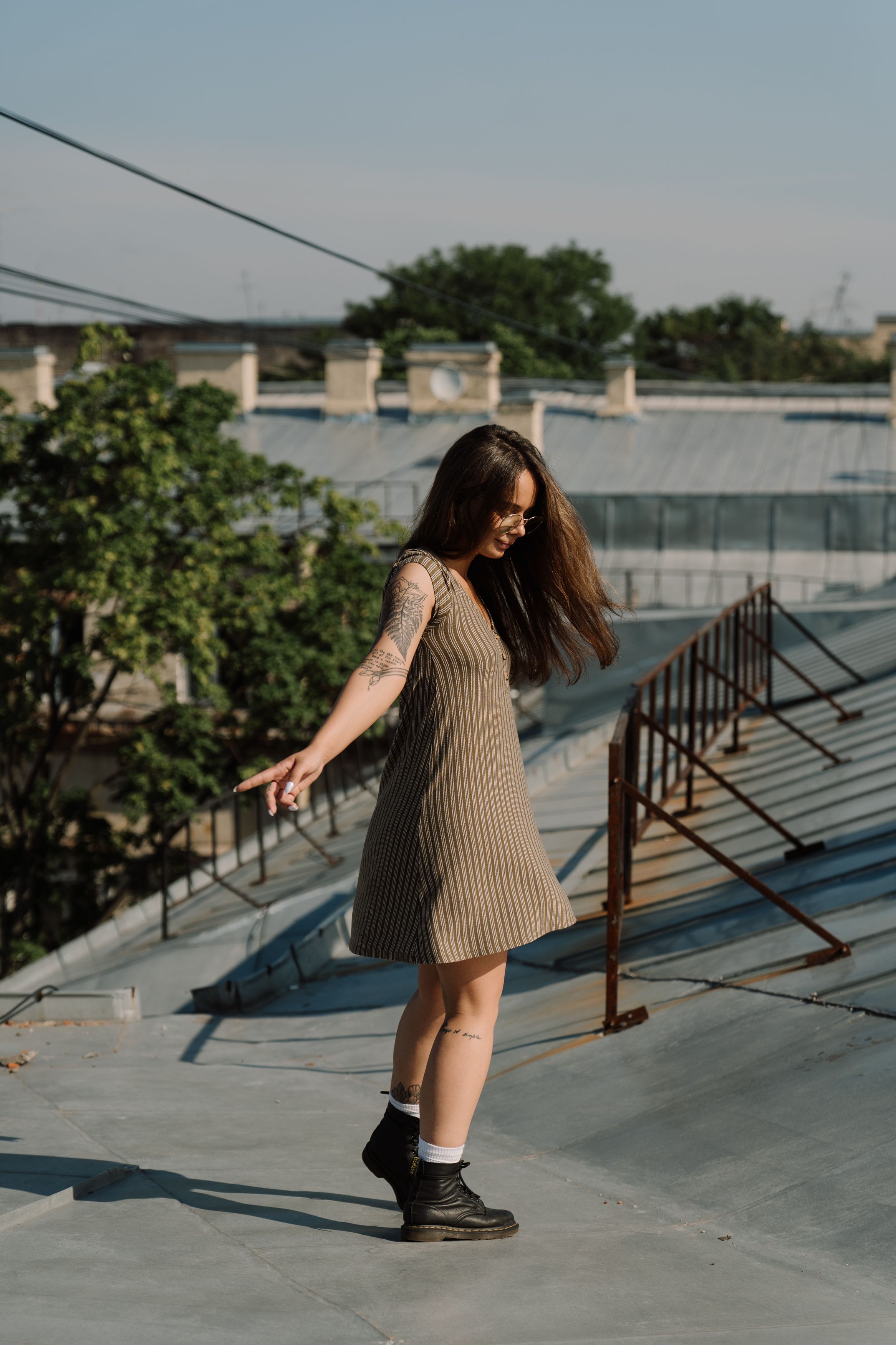 年轻女子穿着夏装，在城市屋顶上享受阳光