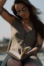 Woman in Black and White Stripe Sleeveless Shirt Reading Book