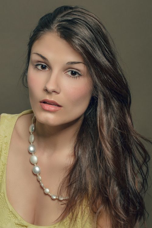 Free A captivating portrait of a woman wearing a pearl necklace, showcasing elegance and beauty. Stock Photo