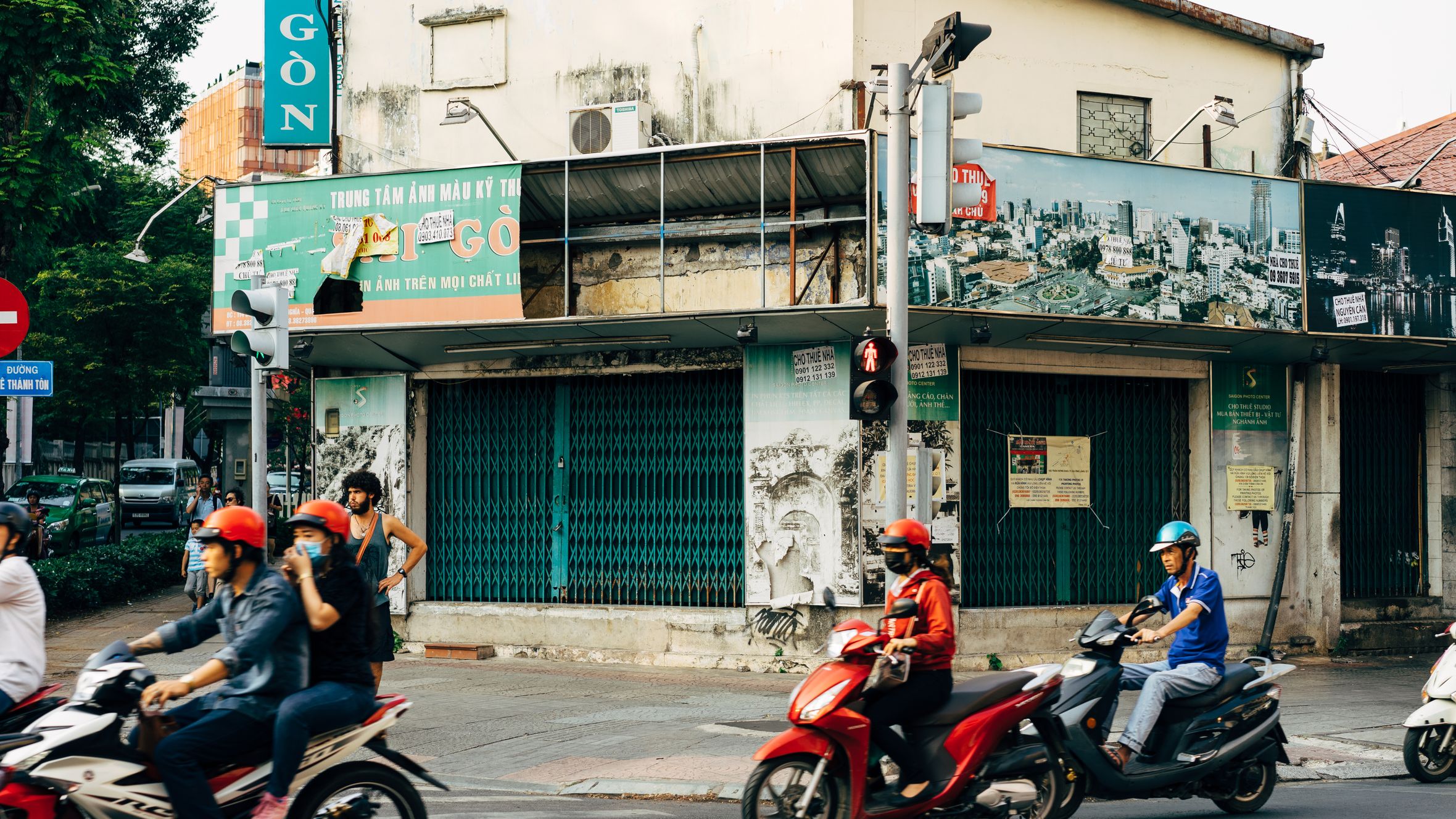 Motorcyclists navigate a vibrant street in Ho Chi Minh City, showcasing urban life and culture.