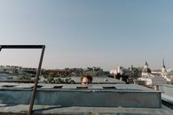 Woman in Black Shirt Sitting on Top of a Building