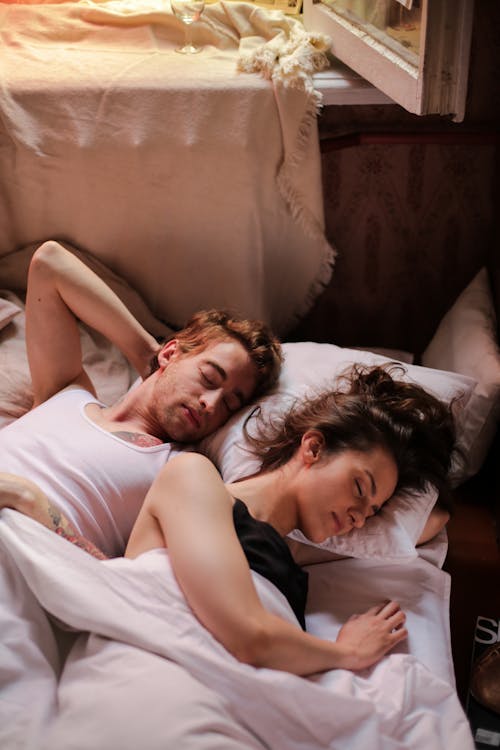 Woman in White Tank Top Lying on Bed