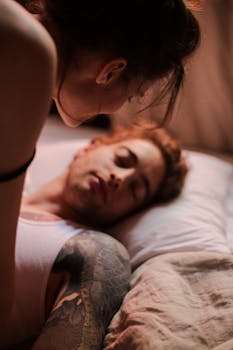 A warm, intimate scene of a couple waking up together in a bedroom setting.