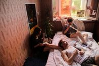 三个朋友在舒适的卧室里，一边阅读一边听黑胶唱片，放松身心