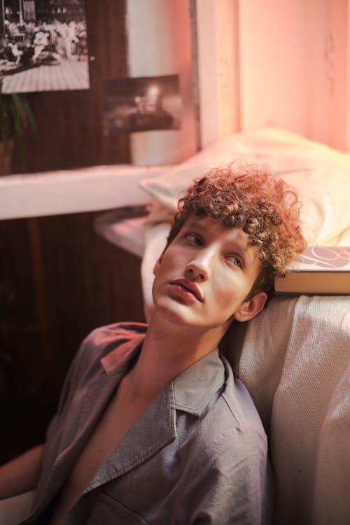 Free Woman in Gray Button Up Shirt Lying on Bed Stock Photo