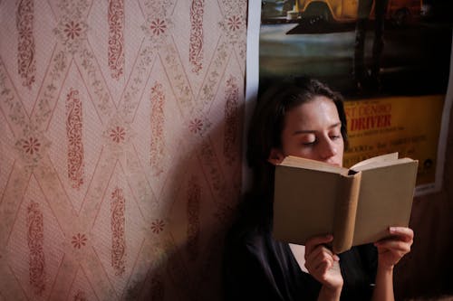 Woman in Black Jacket Holding White Book