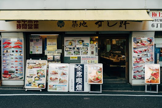 Front view of a traditional sushi restaurant in Tokyo with vibrant menu displays.