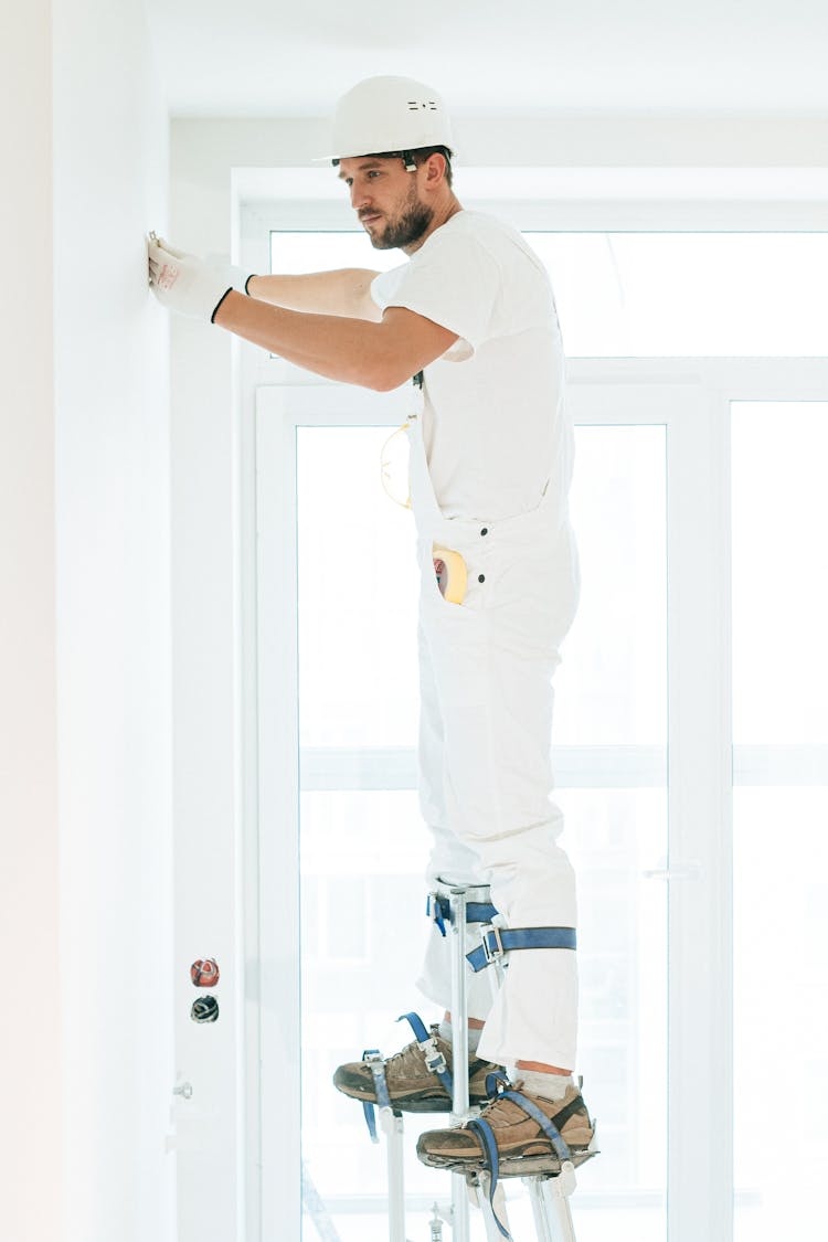 A Man Repairing A Wall