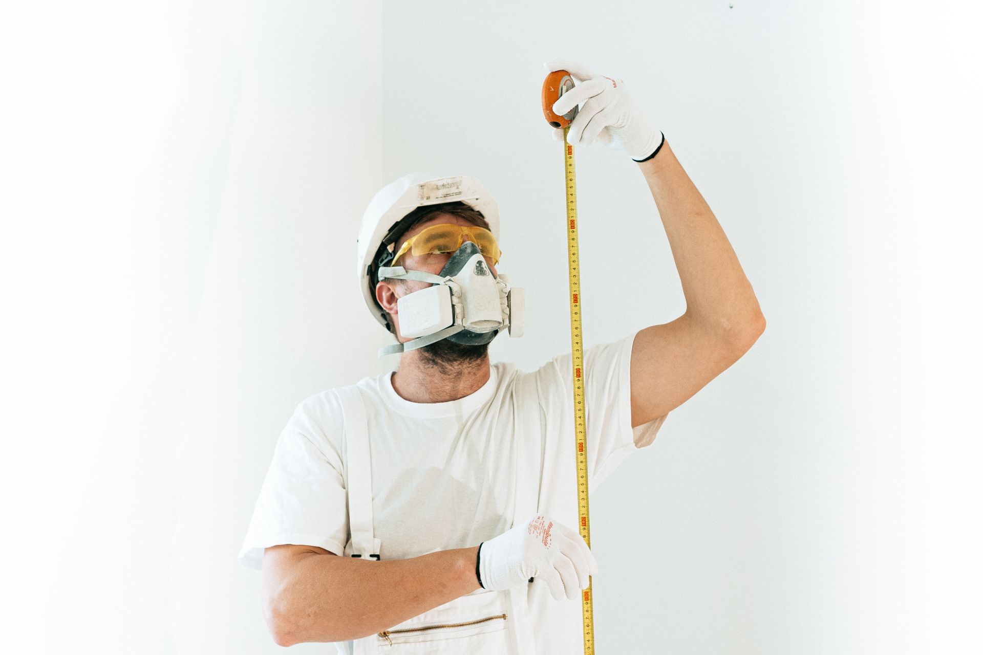 A Man Wearing Safety Glasses While using Tape Measure