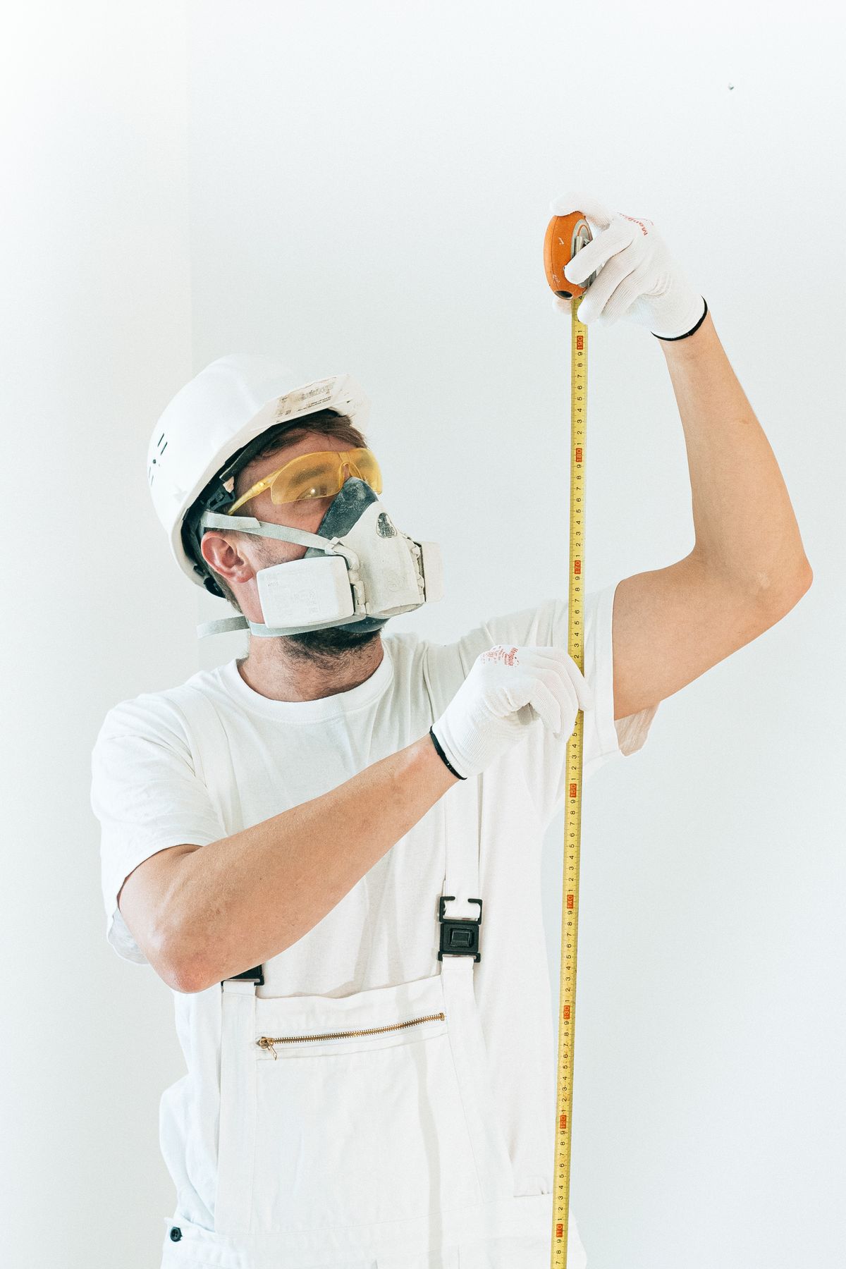 Handwerker mit Maßband beim Ausmessen einer Wand
