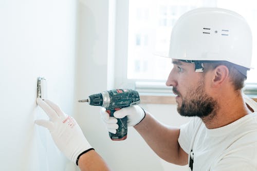 Free A Man Wearing Safety Helmet using Power Tool Stock Photo