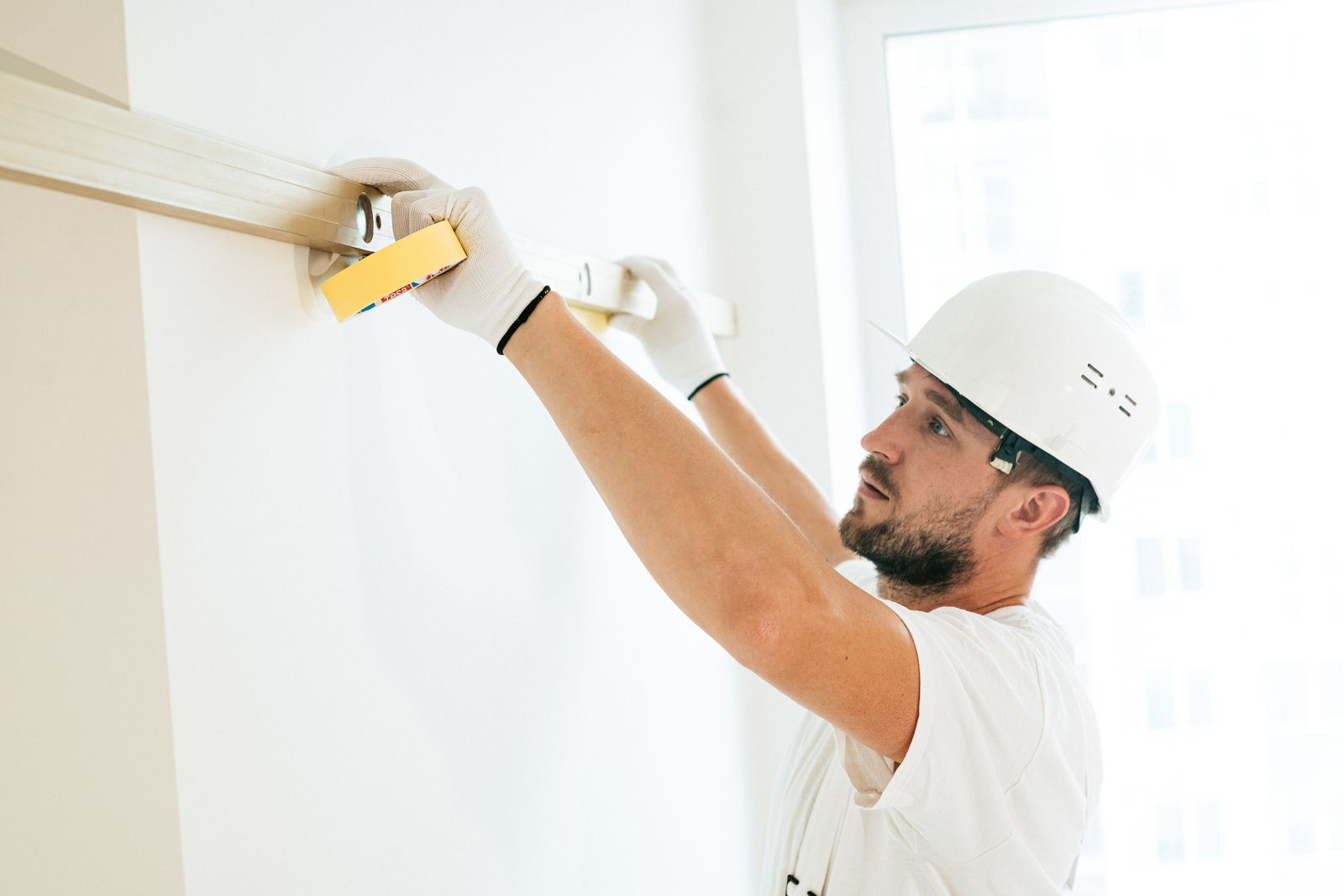 Akeem Construction craftsman measuring a wall