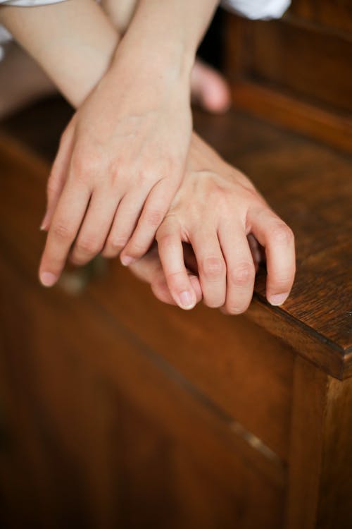 Persons Hand on Brown Wooden Table