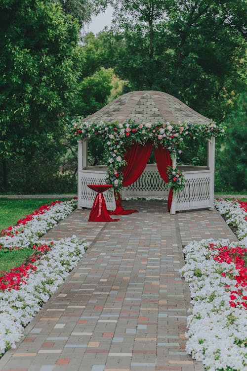 Exterior of decorated wedding terrace with colorful flowers and gazebo in green garden in daytime