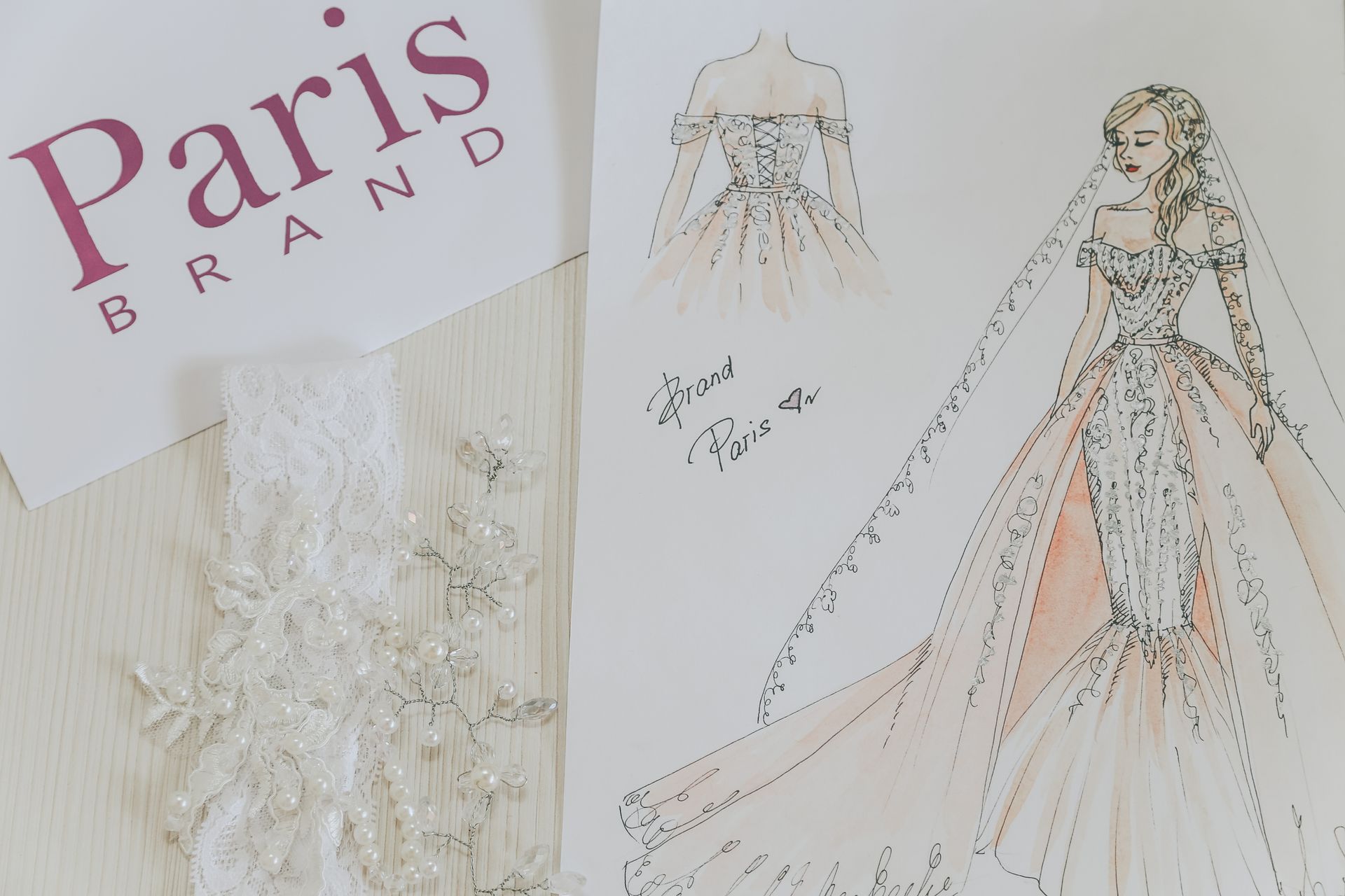 From above of paper with design of bride dress and decoration on white table