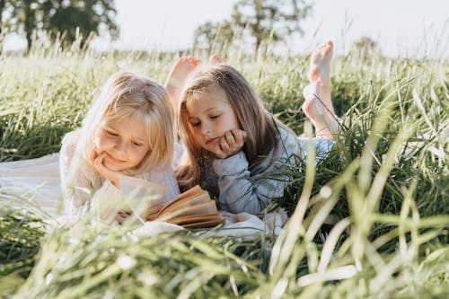 Girls Lying on Grass Field