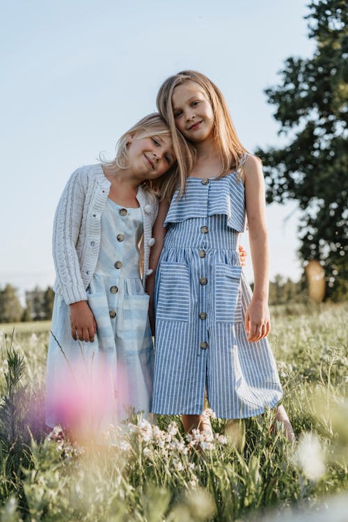 Girls Standing on Green Grass Field