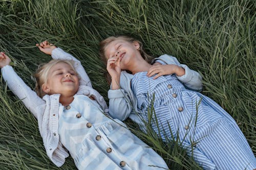 Free Two Young Girls Lying Down on the Grass Stock Photo