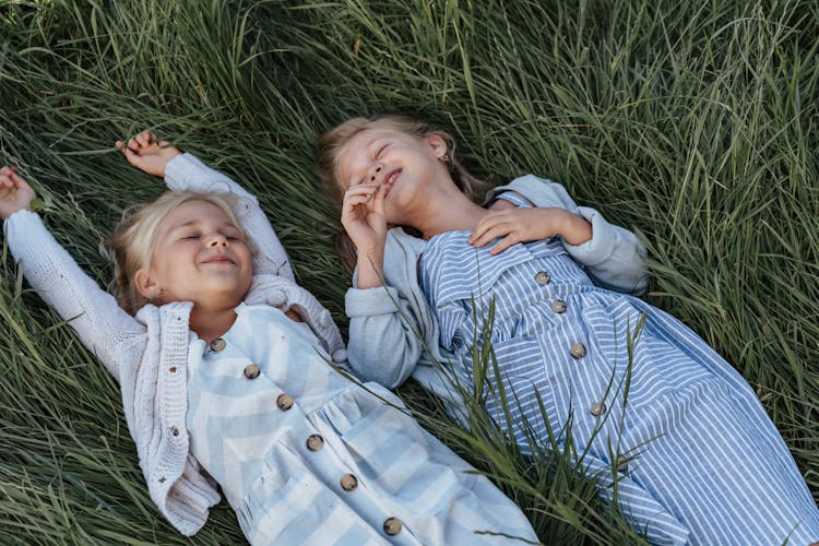 Two Young Girls Lying Down On The Grass