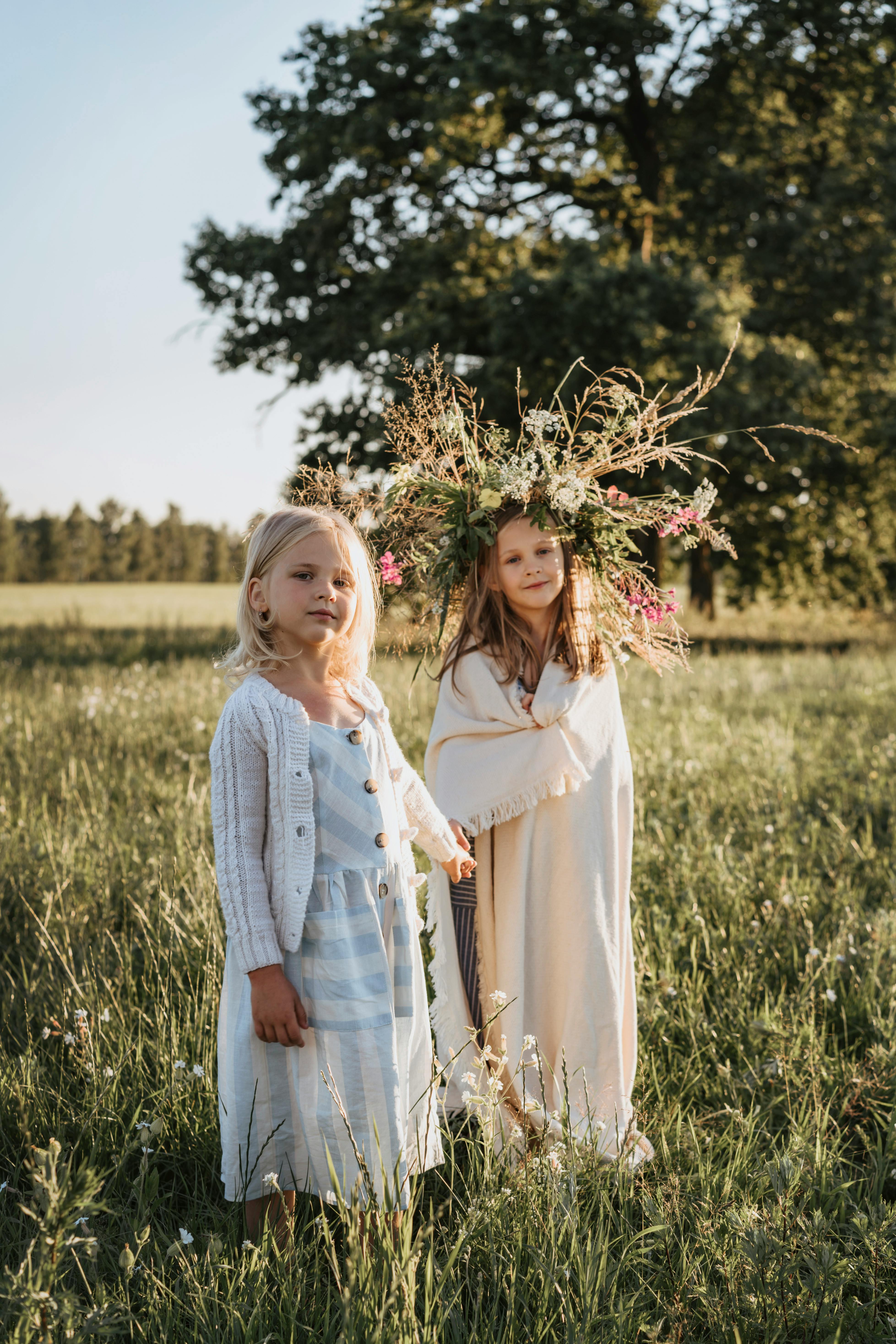 little girls standing on a grass field