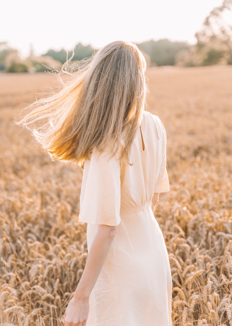 Young Woman In Field At Sunset