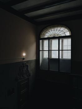 空房间内部昏暗，设有拱形窗户和极简主义设计元素