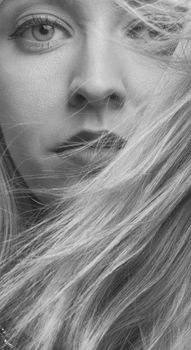 Intriguing close-up black and white portrait of a woman, highlighting expressive details.