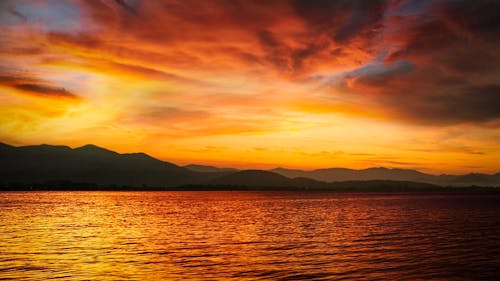 akşam karanlığı, dağlar, deniz içeren Ücretsiz stok fotoğraf